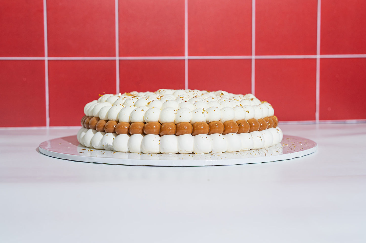 Side view of Banana Pavlova with layers of gluten free meringue, dulce de leche, banana slices and whipped cream