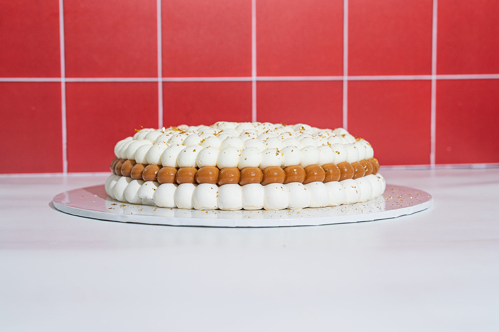 Side view of Banana Pavlova with layers of gluten free meringue, dulce de leche, banana slices and whipped cream